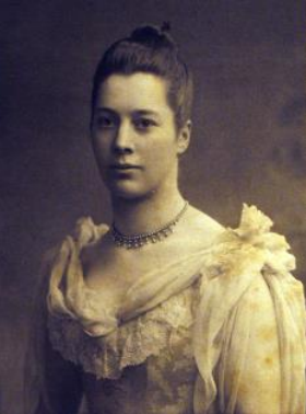 A sepia portrait of Beatrice Chamberlain as a young woman, in an elegant frilled dress.