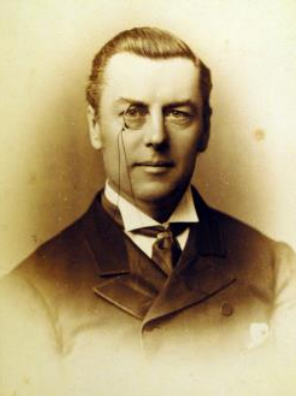 A portrait of Joseph Chamberlain wearing a black suit, a wing collar and a monocle.
