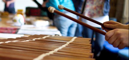 Photo of students playing a musical instrument during a workshop