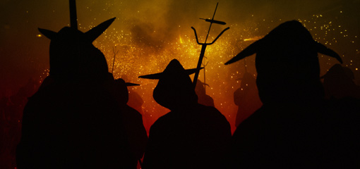 Photograph of silhouetted figures ina torchlit procession