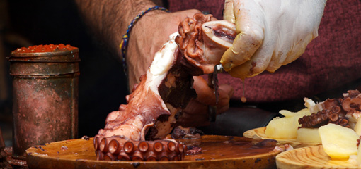 Photograph of a chef slicing an octopus