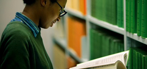 Photograph of a student at a shelf in the library