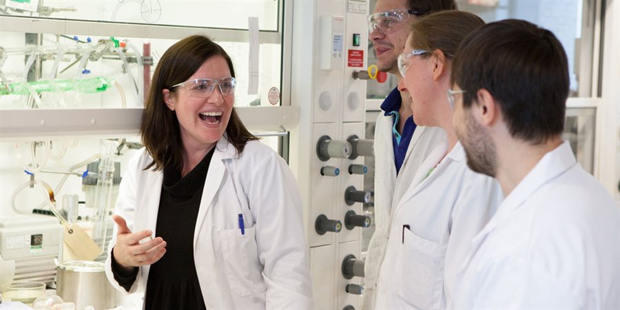 Professor Rachel O'Reilly in a laboratory laughing with students