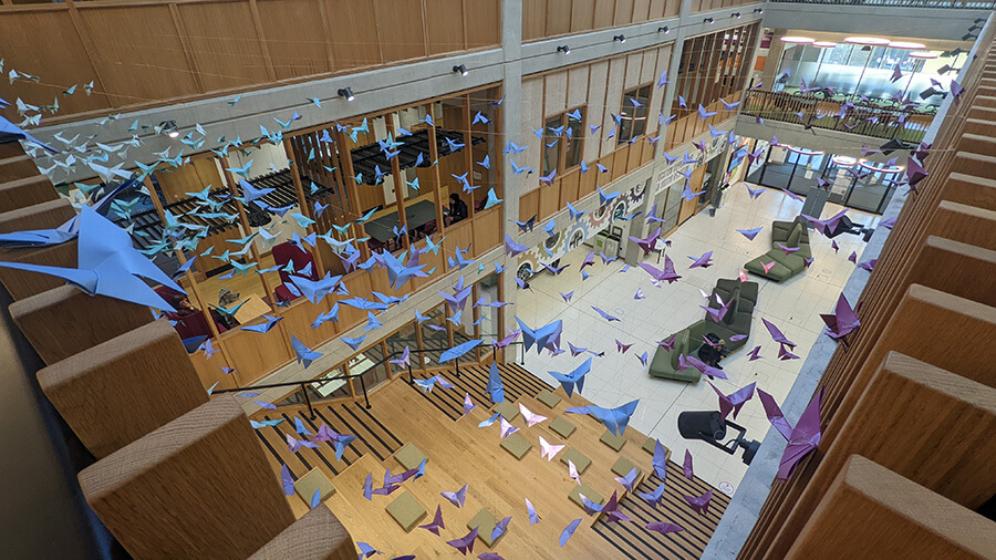 Aerial view of origami butterflies suspended over the University of  Birmingham School of Engineering building