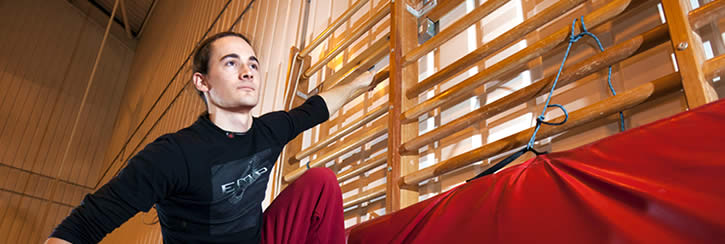 Free runner hangs on wall bars in movement study