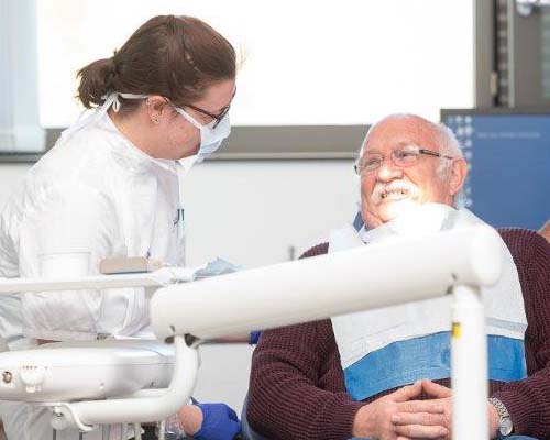 Female dental student talking to a male patient