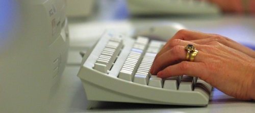 Photo of hands at a compuoter keyboard.