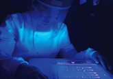 Photograph of a researcher in a biomedical suit