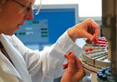 Photograph of a researcher handling test tubes in a lab
