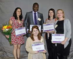 Award recipients display their certificates.