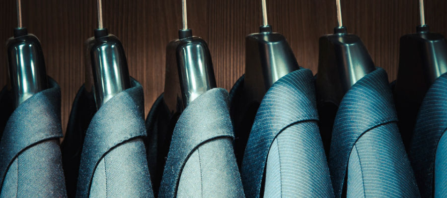 Row of suits hanging in a wardrobe