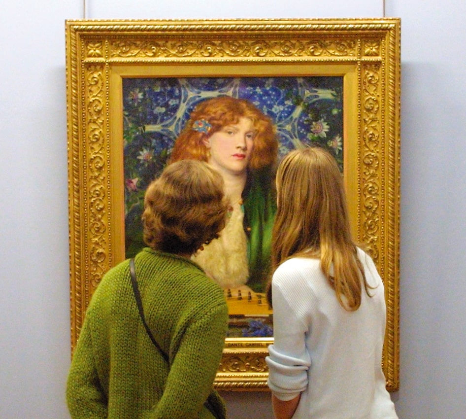 Two visitors to the Barber Institute of Fine Arts looking at Dante Gabriel Rossetti's 'The Blue Bower' painting 