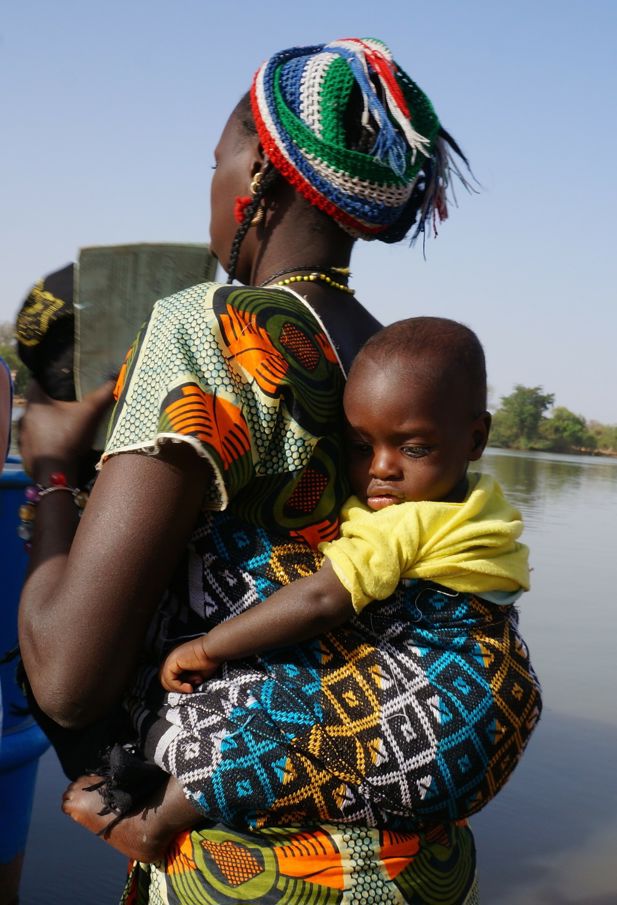 A mother carrying a child on her back.