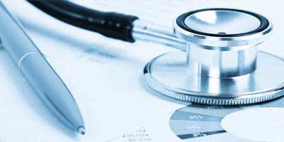 Stethoscope and pen on top of sheet containing medical data
