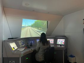 Nusrat Ghani MP Minister of State at the Department for Business, Energy and Industrial Strategy sat at a train simulator at the UK Rail Research and Innovation Network building