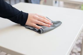 person wiping a table with a cloth