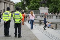 Two Met police officers standing in Trafalgar Square.  