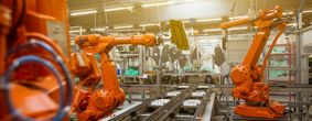 Orange robots operating in a factory