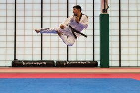 Taekwondo athlete demonstrating a flying side kick