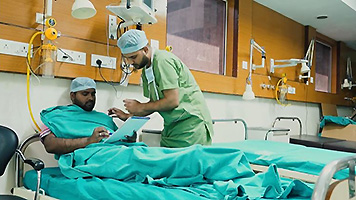 A doctor talks to a patient in a hospital bed