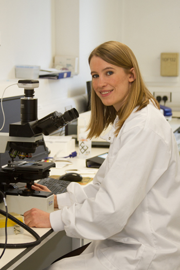 Sophie Cox in laboratory with microscope