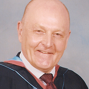 John McNamara, alumnus of the year for 2005, smiles to camera