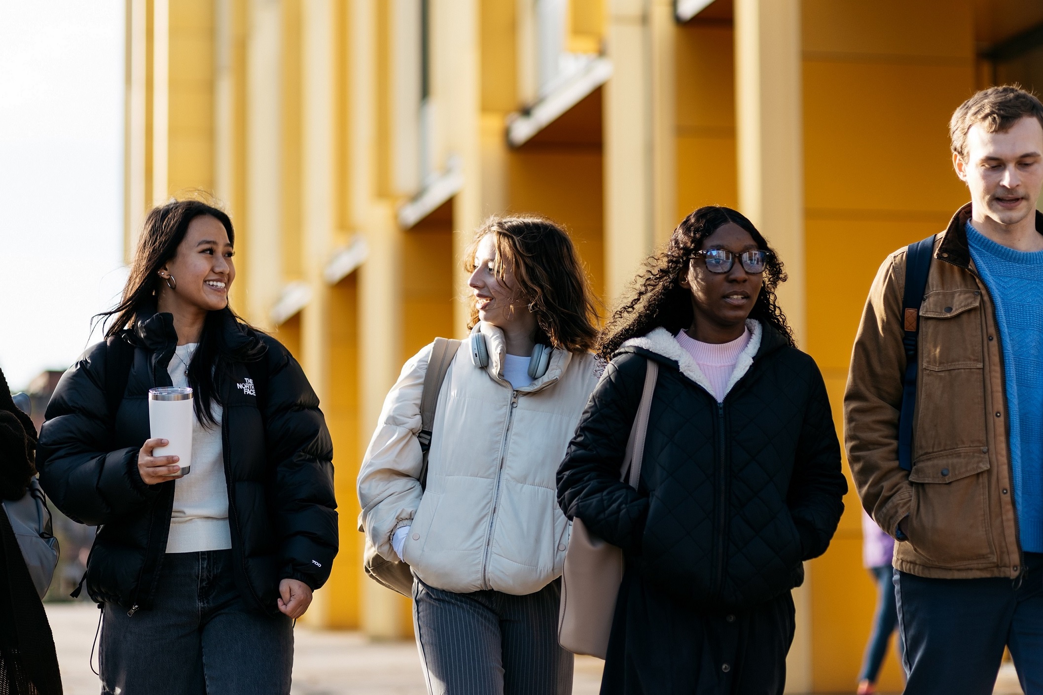 3 students walk through campus