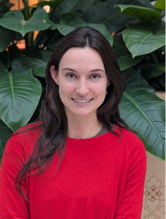A young woman with long hair, smiling.