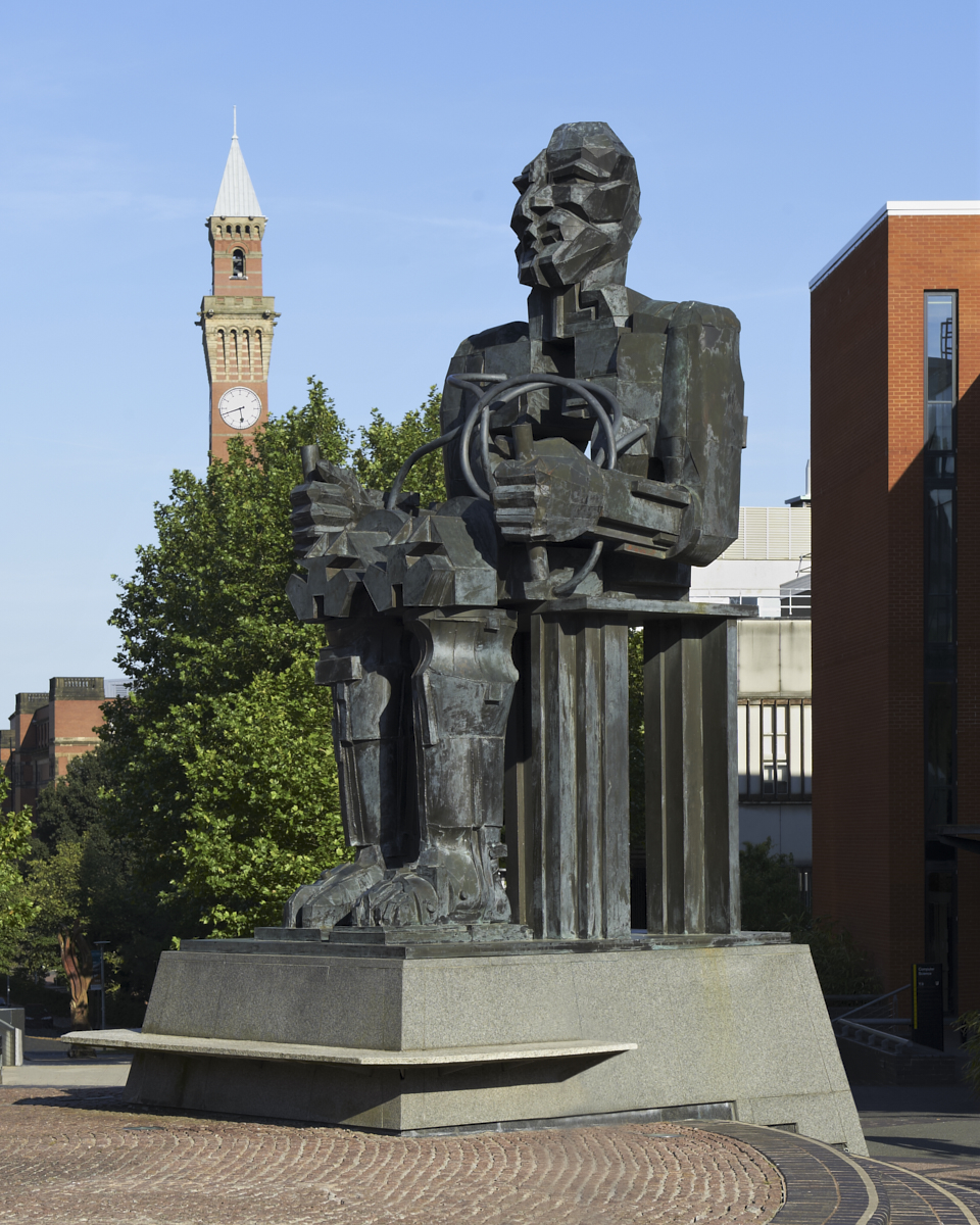 Faraday bronze sculpture with clock tower and tree in background by Eduardo Paolozzi