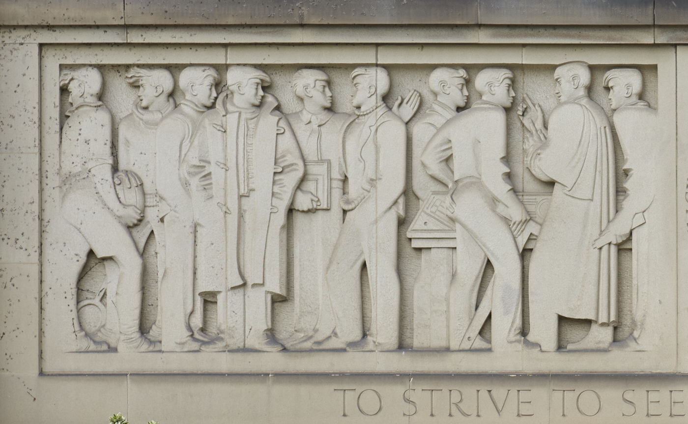 Close up detail of left side of stone carved Engineering Frieze by William Bloye showing ten men stood in a row