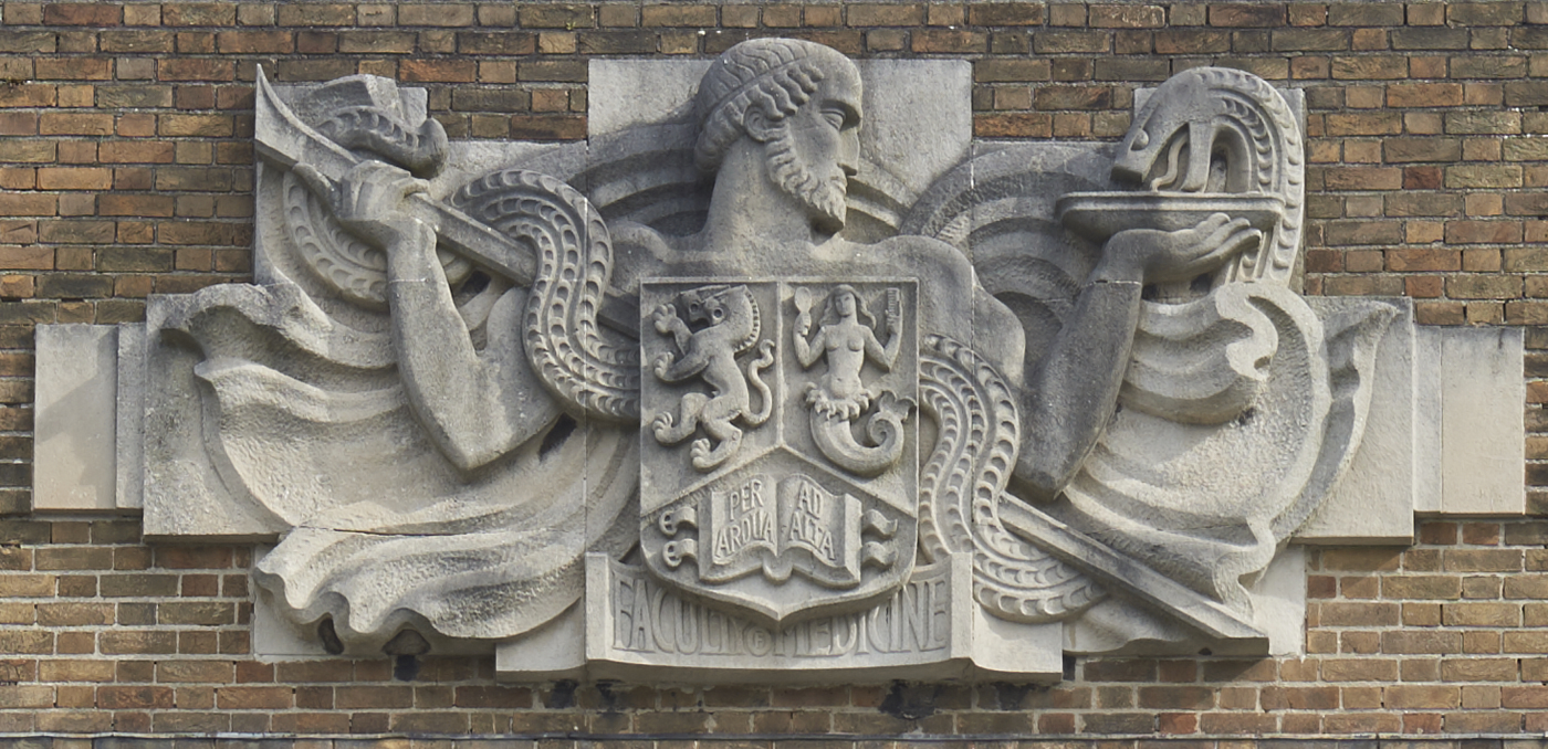 Carved stone shield featuring a male figure and a serpent on the front of the Medical School by William Bloye