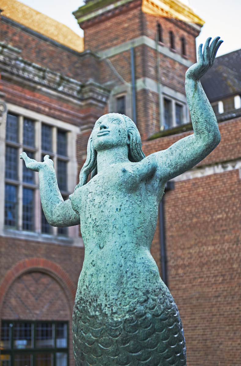 Torso, arms and head of Mermaid Fountain bronze sculpture by William Bloye with Guild of Students behind