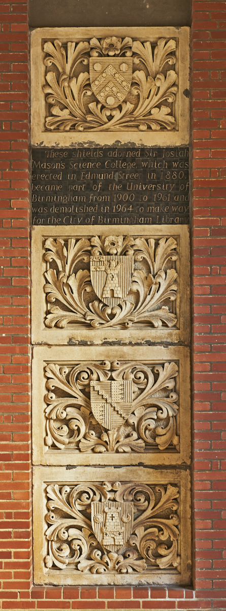 Vertical column of four stone, carved plaques and written panel from Heraldic Shields from Mason College