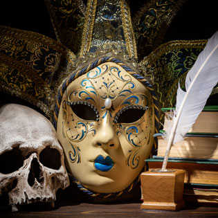 Ornate theatrical masks and a quill in a moody photograph