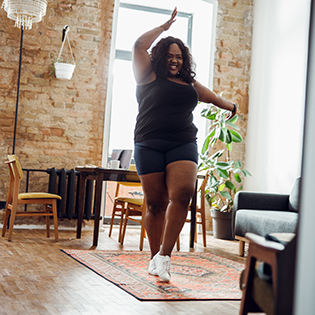 Happy woman smiling and dancing alone in sports clothes