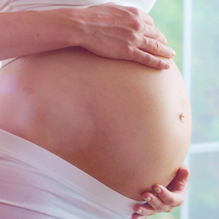 a woman's hands on a pregnant stomach