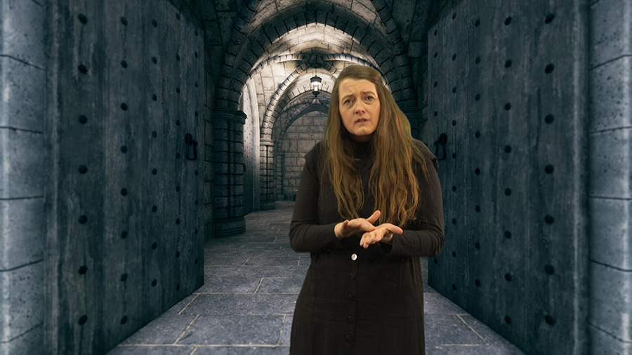 An actor speaking in sign language in front of a stone corridor