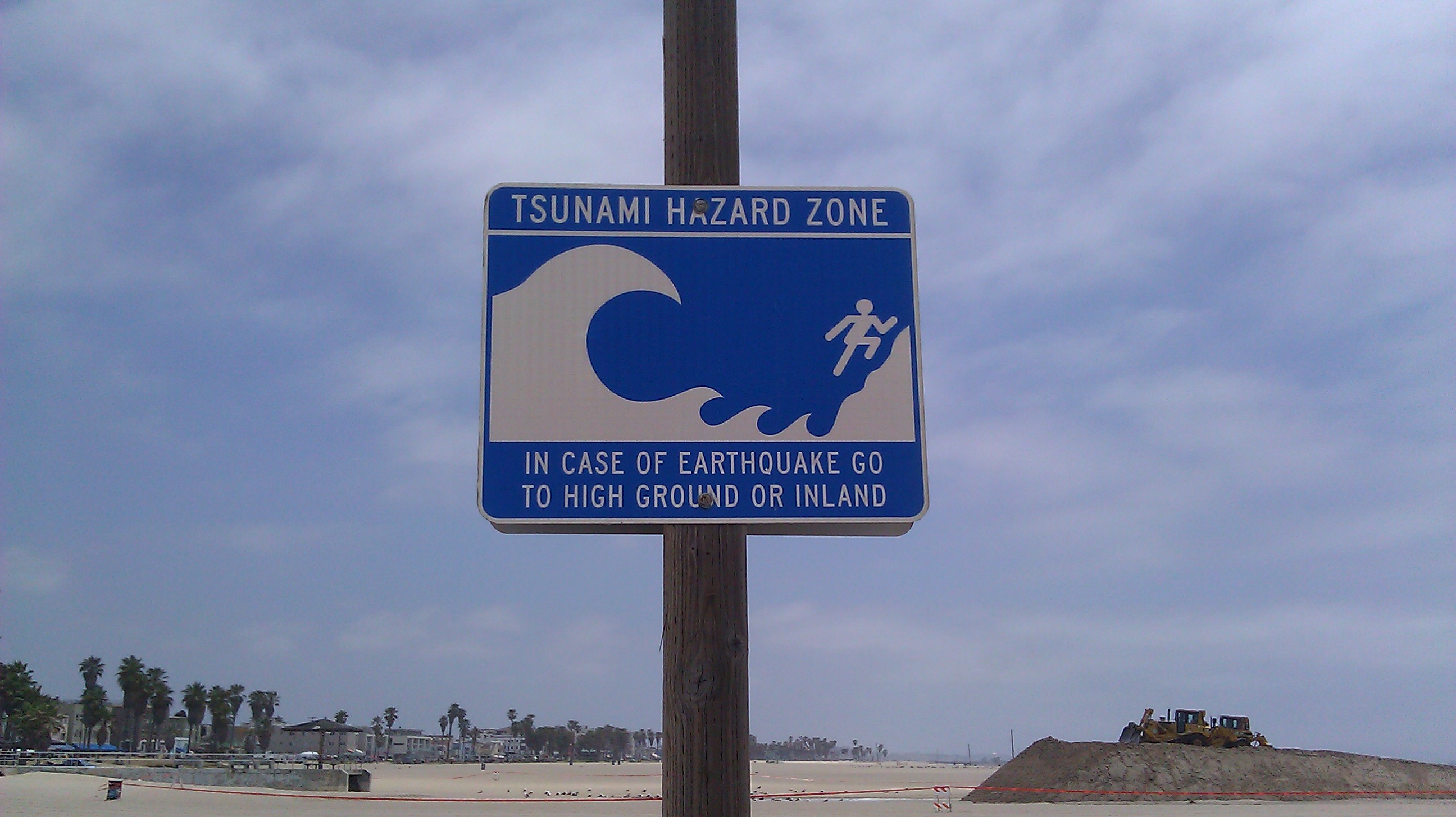 A picture of a signpost for a Tsunami Hazard zone.