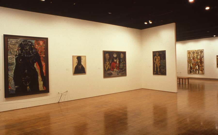 A photograph of an installation of The Other Story exhibtion at The Hayward Gallery, showing a number of oil paintings hanging on a wall.
