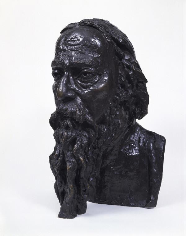 Bronze head of a middle-aged man with a long beard and eyes wide open. He has a furrowed brow and hair down to his collarbone.
