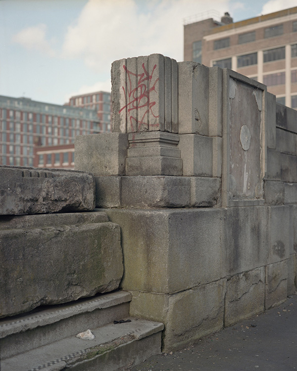 Part of the remnants of a building in stone, in which we see the base of a pilaster.