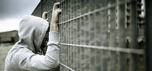 Photograph of a lonely man at a fence, for the Prison Cohesion web page