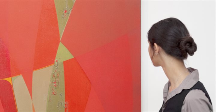 A woman looks at an abstract painting