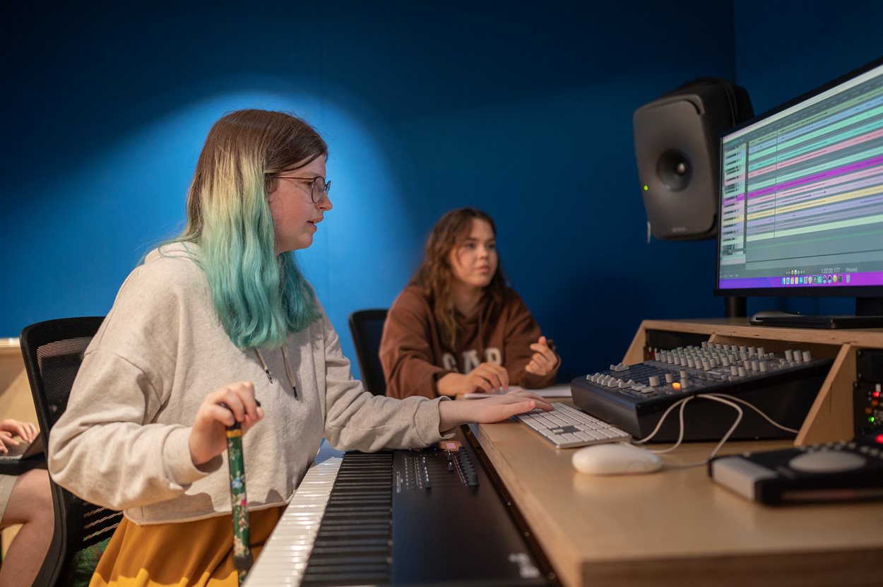 Students working in the University Music Hub recording studio