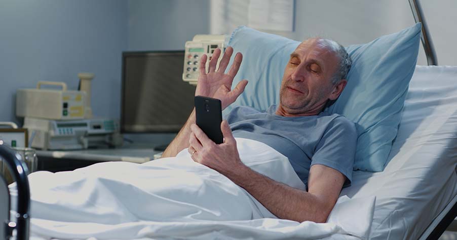 Senior adult patient using video call in hospital room