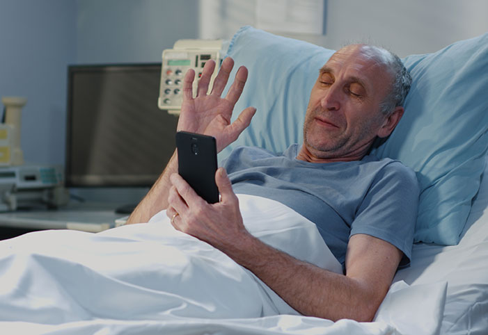 a man speaks engages in a video call from a hospital bed