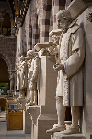 Three sculptural figures in columned arcade
