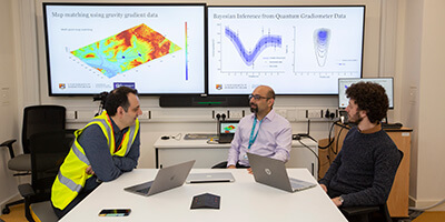 National Buried Infrastructure Facility researchers working in a room with large screens in the background