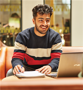 Man smiling looking at his laptop
