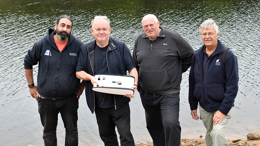 Members of the HIT Team by Burrator Reservoir with Professor Bob Stone holding mini remotely operated vehicles